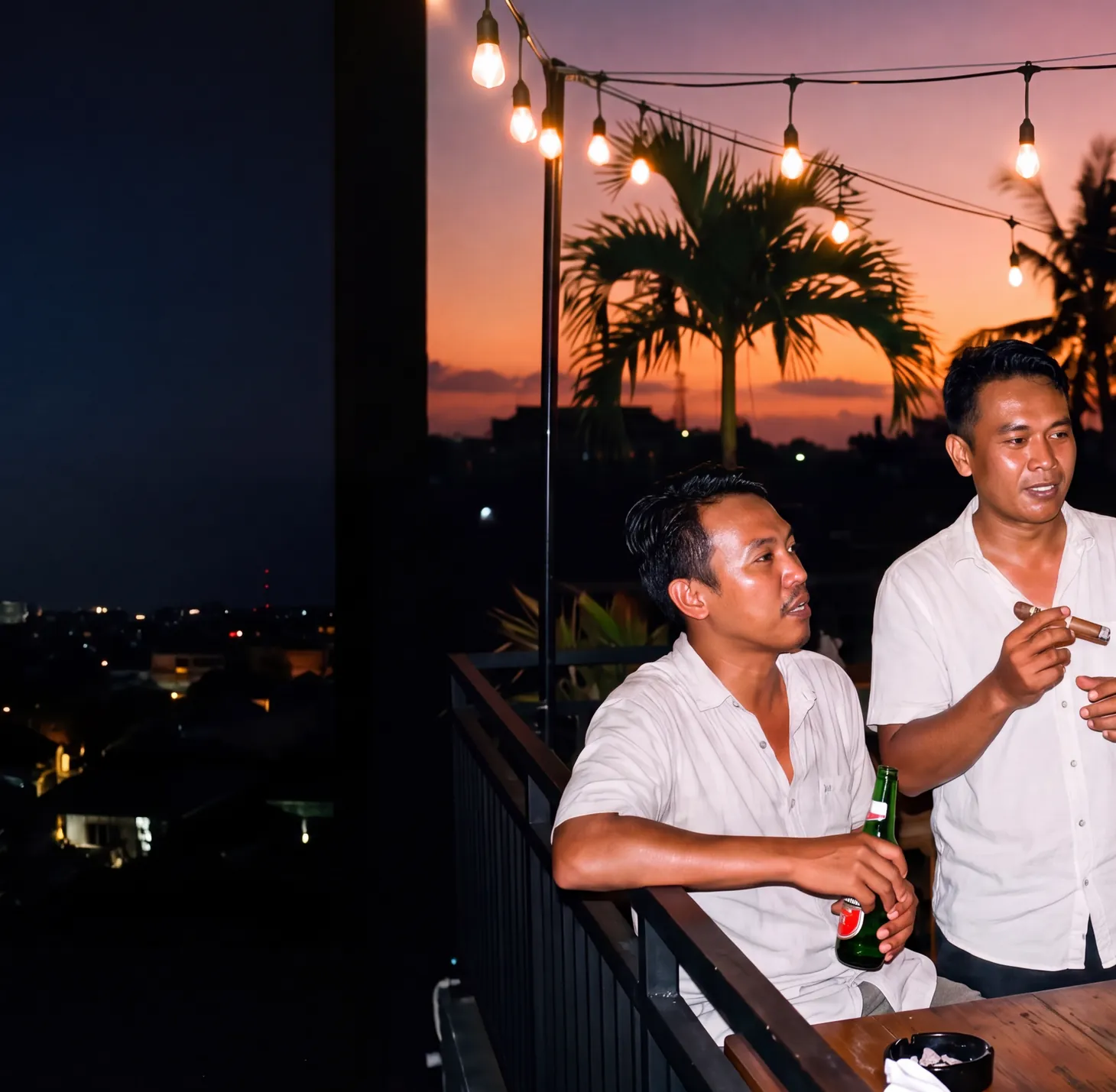 Friends sharing cigars on a rooftop at dusk under string lights